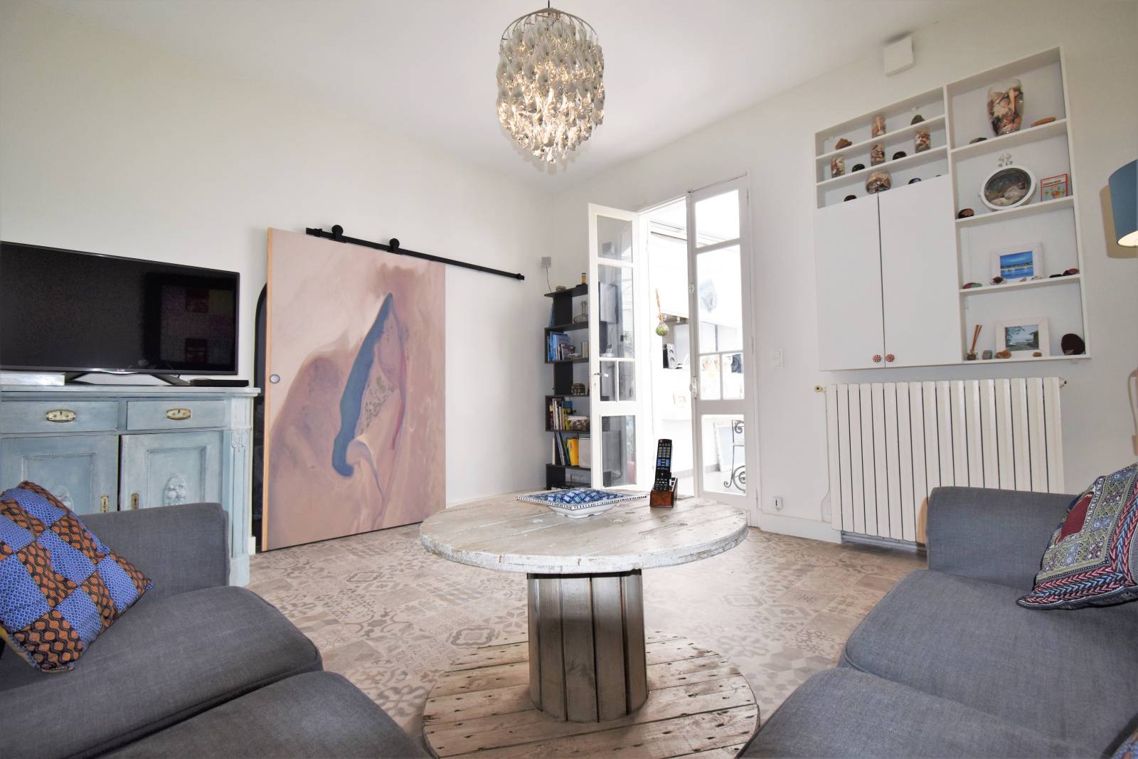 Salon chaleureux ouvrant sur l’espace nuit dans une maison de ville à Taussat-les-Bains