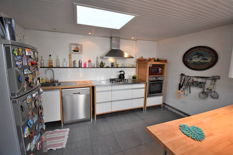 Cuisine semi-ouverte équipée dans une maison de 90 m² à vendre proche commerces et littoral